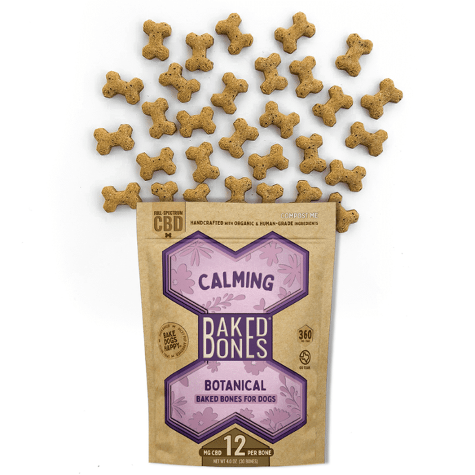 Golden-brown baked dog bones spilling out of a Kraft BakedBones bag with a purple bone and 